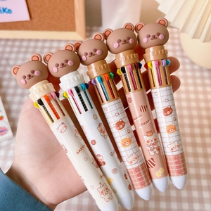 Detail of multi-color ballpoint pens featuring cute 3D brown bear toppers and grid patterns