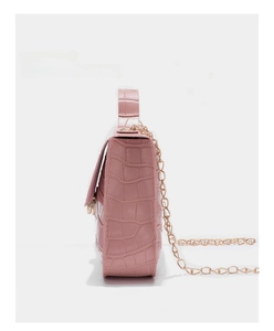 Side view of pink crocodile pattern crossbody bag with golden chain and leather handle