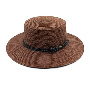 Detail of a brown straw boater hat featuring a flat brim and black woven decorative cord