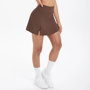 Dettaglio della gonna-pantalone sportiva marrone scuro a vita alta con spacco laterale