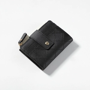 Detail of black quilted leather wallet with gold zipper and snap button closure