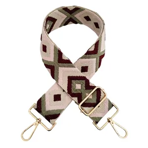 Detail of geometric jacquard shoulder strap in wine red and green with gold buckle