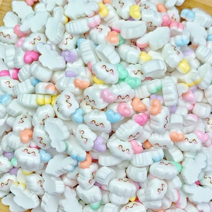 Macro detail of white resin cloud charms with colorful hearts and smiley faces for DIY