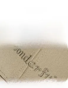 Detailed view of golden 'Wonderful' embroidery on khaki cotton baseball cap fabric