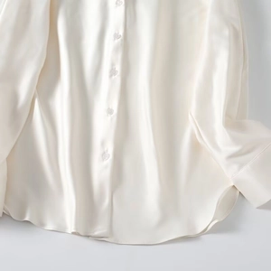 Detailed close-up showing the smooth satin fabric texture and drape of this silk shirt