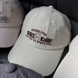 Close-up of stacked baseball caps with 3D Friday embroidery and bear motif detail
