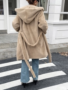 Vue arrière d'un manteau beige à capuche en fausse fourrure pelucheuse avec une ceinture