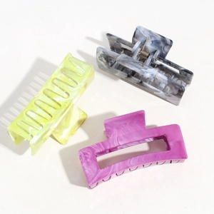 Detailed view of three rectangular hollow hair claws with colorful marble patterns