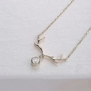 Close-up of silver elk antler pendant necklace with brilliant cut zircon gemstone