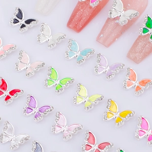 Detail of 3D butterfly nail charms with rhinestones and colorful enamel on long nails