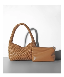 Dettaglio borsa hobo intrecciata con pochette coordinata in pelle sintetica caramello
