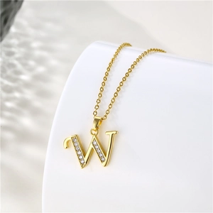 Close-up of a 18K gold plated letter W pendant with sparkling zircon stone setting