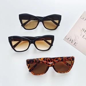 Detailed flat lay of chic cat eye sunglasses in black and tortoiseshell finishes