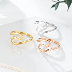 Three-color S-shaped wave rings in gold silver and rose gold finishes on white stone