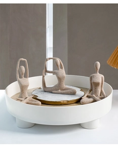 Close-up of minimalist ceramic yoga figurines set with a natural sandstone matte texture