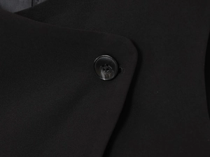 Macro view of black twill fabric texture and matching four-hole button on the vest