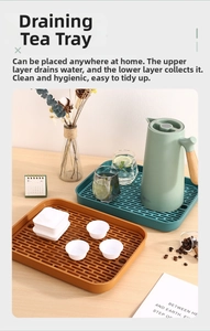 Vue détaillée d'un plateau à thé vert à double couche avec grille de drainage sur table en bois