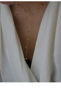 Detail of 18k gold plated Y-shaped necklace with small beads on a minimalist chain