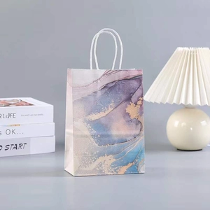 Detail of marble pattern gift bag with purple and gold fluid art and rope handles