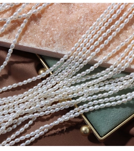 Detailed view of 4mm white freshwater rice pearls with high luster on silk fabric