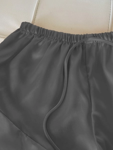 Détail du short de nuit en satin gris foncé avec taille élastique et texture de soie