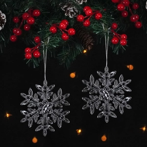 Close-up of two clear acrylic snowflake ornaments with silver strings for Christmas tree