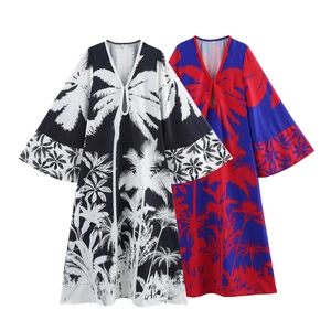 Detail view of V-neck tropical palm tree print dresses in black-white and red-blue patterns
