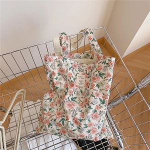 Sac fourre-tout à fleurs roses placé dans un chariot en métal argenté brillant