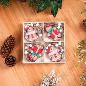 Detail of wooden gingerbread man ornaments set in a box with pine cones and pine branches
