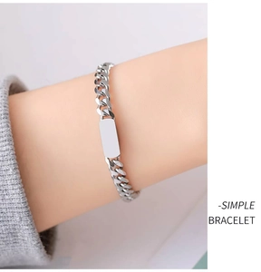 Close-up of minimalist silver titanium steel ID bracelet with flat rectangle plate on wrist