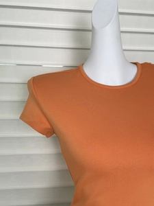 Detailed close-up of orange crew neck short sleeve T-shirt with fine knit texture