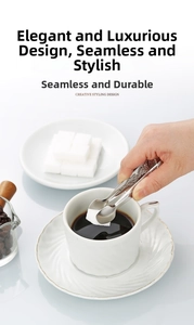 Detail of embossed stainless steel sugar tongs placing a sugar cube into a coffee cup