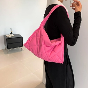 Pink quilted nylon shoulder bag shown on shoulder with soft padded down-like texture