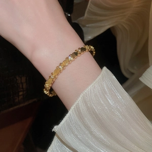 Detailed close-up of 18k gold plated iris flower bracelet with sparkling zircons