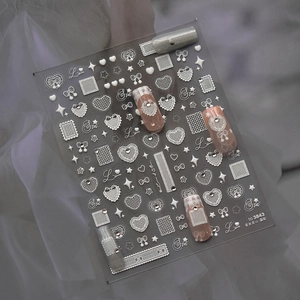 Detail of white lace heart nail stickers with sparkling rhinestones and bows for nail art