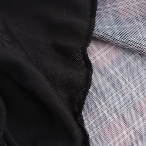 Detailed macro view showing black and pink plaid fabric texture for vintage dress