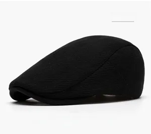 Close-up of black wool newsboy cap showing detailed twill texture and neat stitching