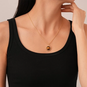 Detail of vintage tiger eye necklace with golden rope chain on model collarbone