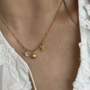 Gold starfish and shell pendant necklace with zircon on a delicate bead chain