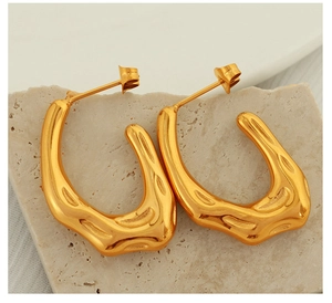 Detail view of gold textured hoop earrings with an irregular hammered finish on stone