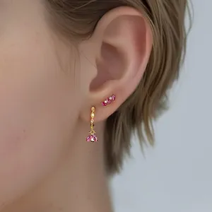 Macro shot of 925 sterling silver gold-plated earrings with marquise pink zirconia