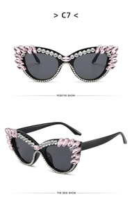Detail of cat eye sunglasses featuring pink rhinestones and dark grey lenses