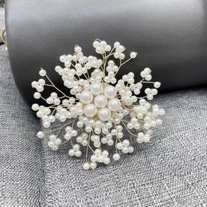 Handgefertigte elegante Perlen-Schneeflocken-Brosche mit Golddraht auf grauem Stoff