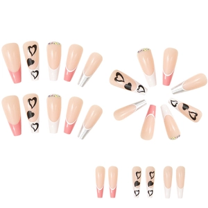 Detailed flat lay of long coffin press-on nails with glitter, rhinestones, and hearts