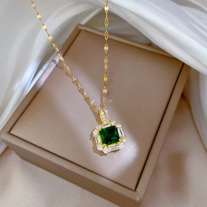 Gold titanium necklace with square emerald green zircon pendant on beige silk