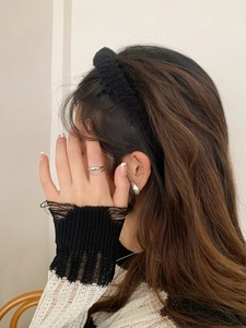 Close-up of a minimalist silver double-layer ring and matching stud earrings on model