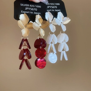 Detailed close-up of S925 floral tassel earrings in gold-burgundy and matte white
