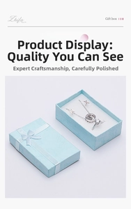 Macro shot of silver necklace and ring set inside a light blue textured jewelry gift box