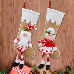 Christmas stockings with Santa and chef plush dolls on a warm wooden background