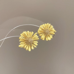 Detailed close-up of yellow daisy stud earrings featuring realistic 3D raffia petals